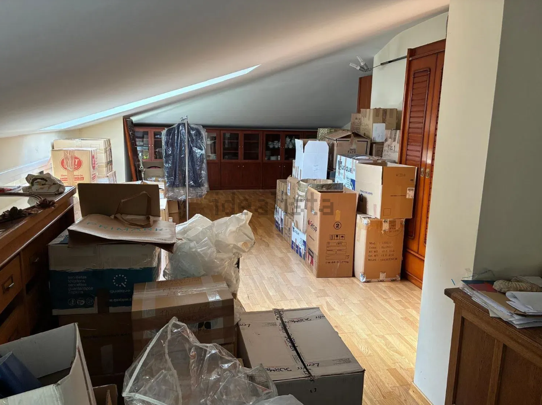 Buhardilla saturada de cajas y ropa en la publicación de la otra inmobiliaria